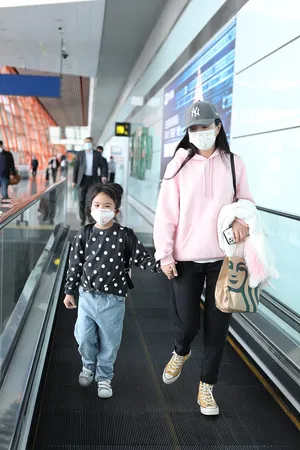包文婧俏皮粉衣带闺女甜蜜牵手机场照图片_1