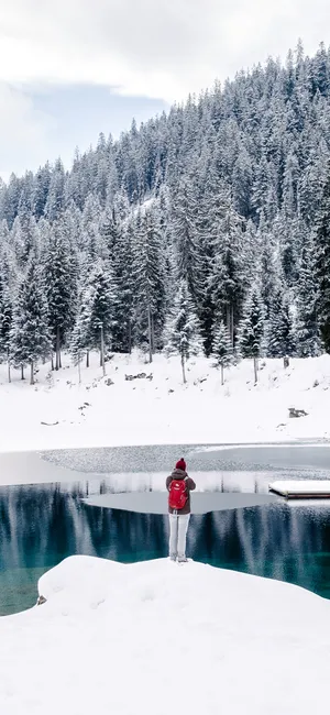 大雪覆盖的雪山森林，爬山摄影的背包客