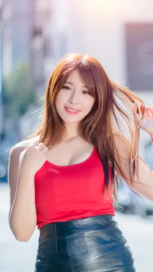 穿红色吊带上衣搭配皮衣短裙的性感大胸美女