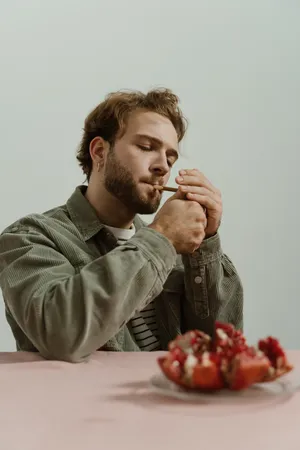 穿绿夹克的男人点燃香烟图片_1