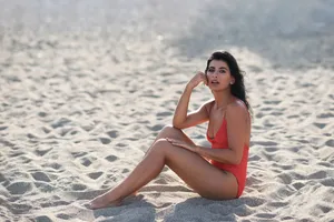 穿着泳装的美女坐在沙滩上图片