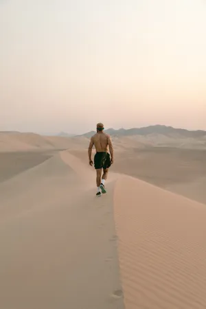 行走在沙漠的男人图片