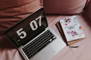 粉色沙发上的电脑和相机的图片第张