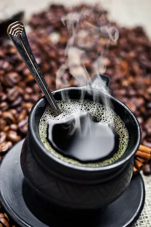 盛满咖啡的黑色咖啡杯图片_1